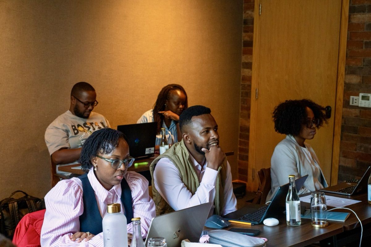 Participants attentively working at desks with laptops during a TID AI Bootcamp classroom session