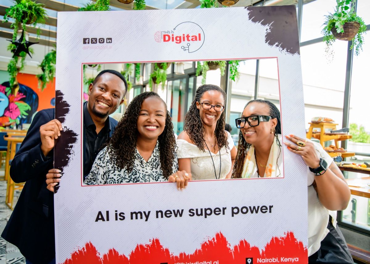 Four people smiling together inside the This Is Digital "AI is my new super power" branded frame at a TID event