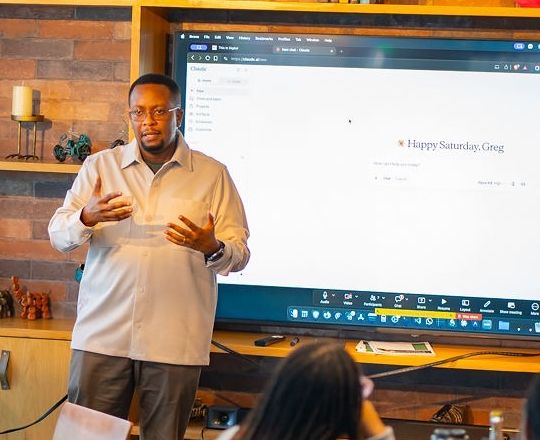 Greg Wanjama presenting at the screen to a seated cohort during a TID training session
